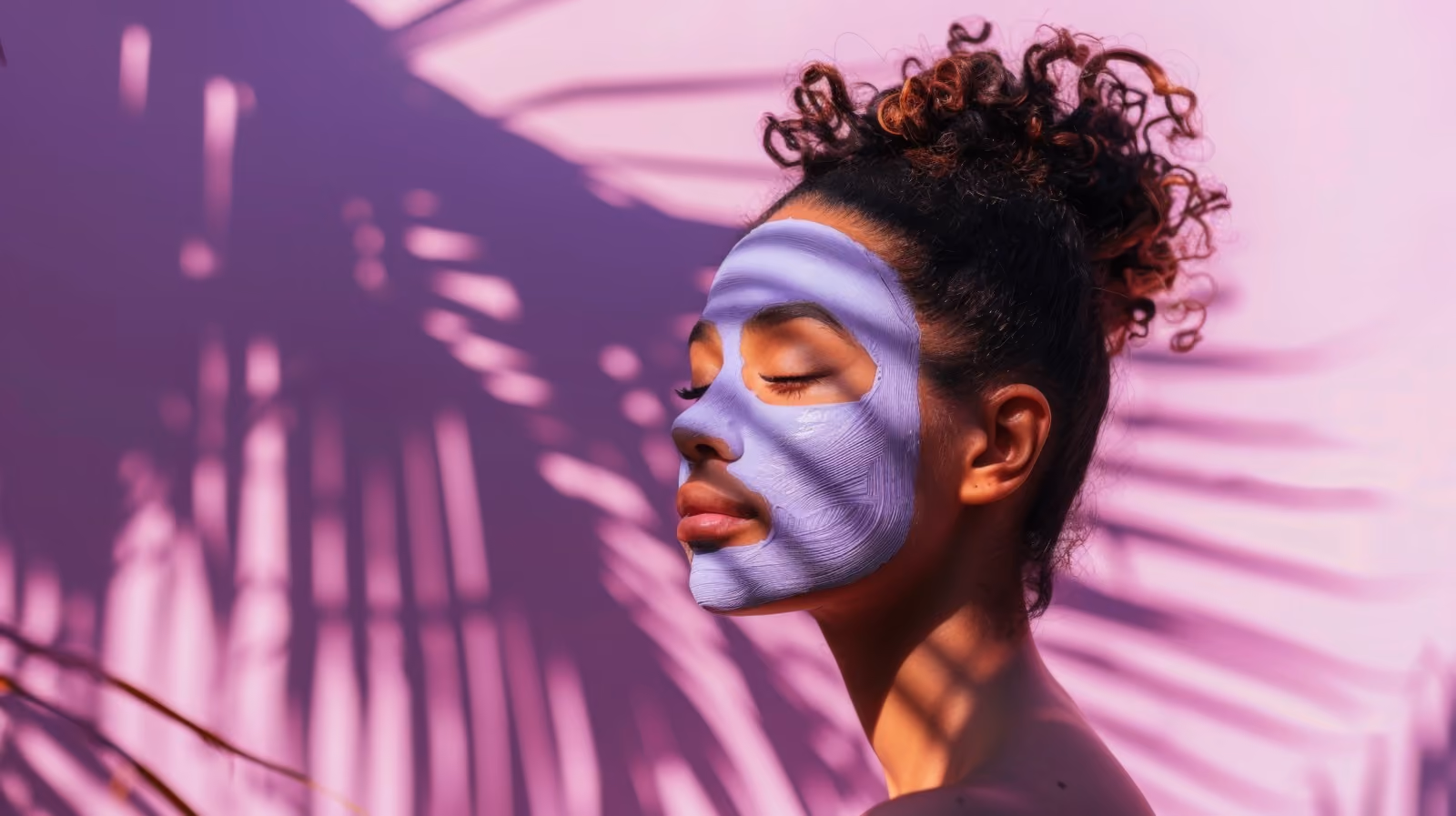 Femme avec un masque de soin sur le visage, détendue au soleil